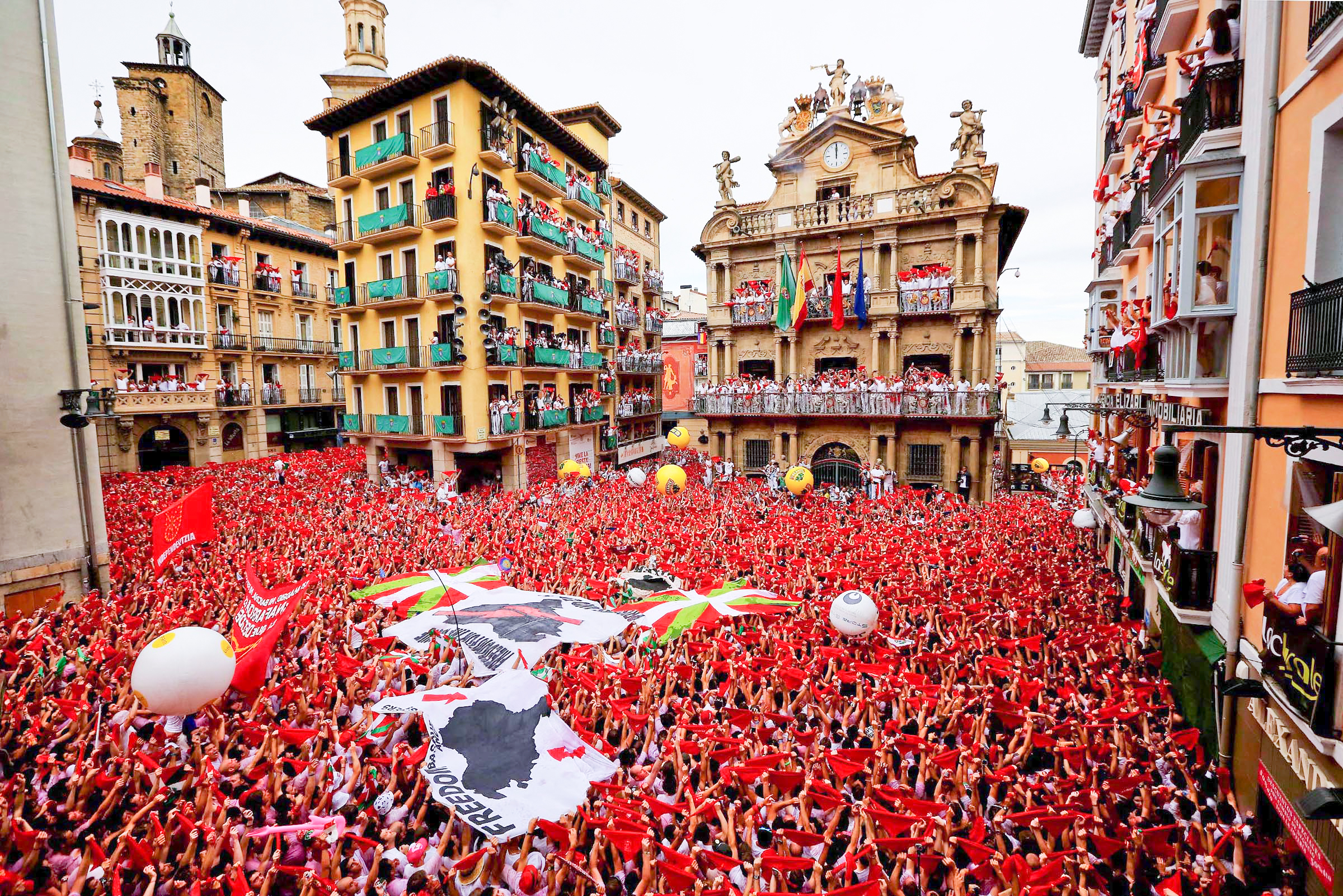 Revelers hold up their handkerchiefs during the opening day of the Running of the Bulls
