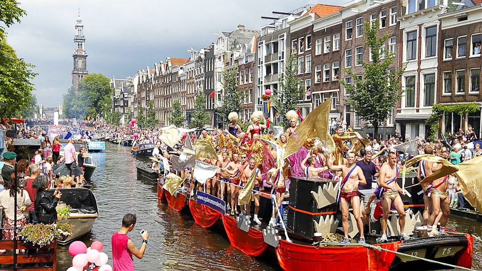 Supporters line the canal to watch the floats of the Amsterdam Gay Pride Parade