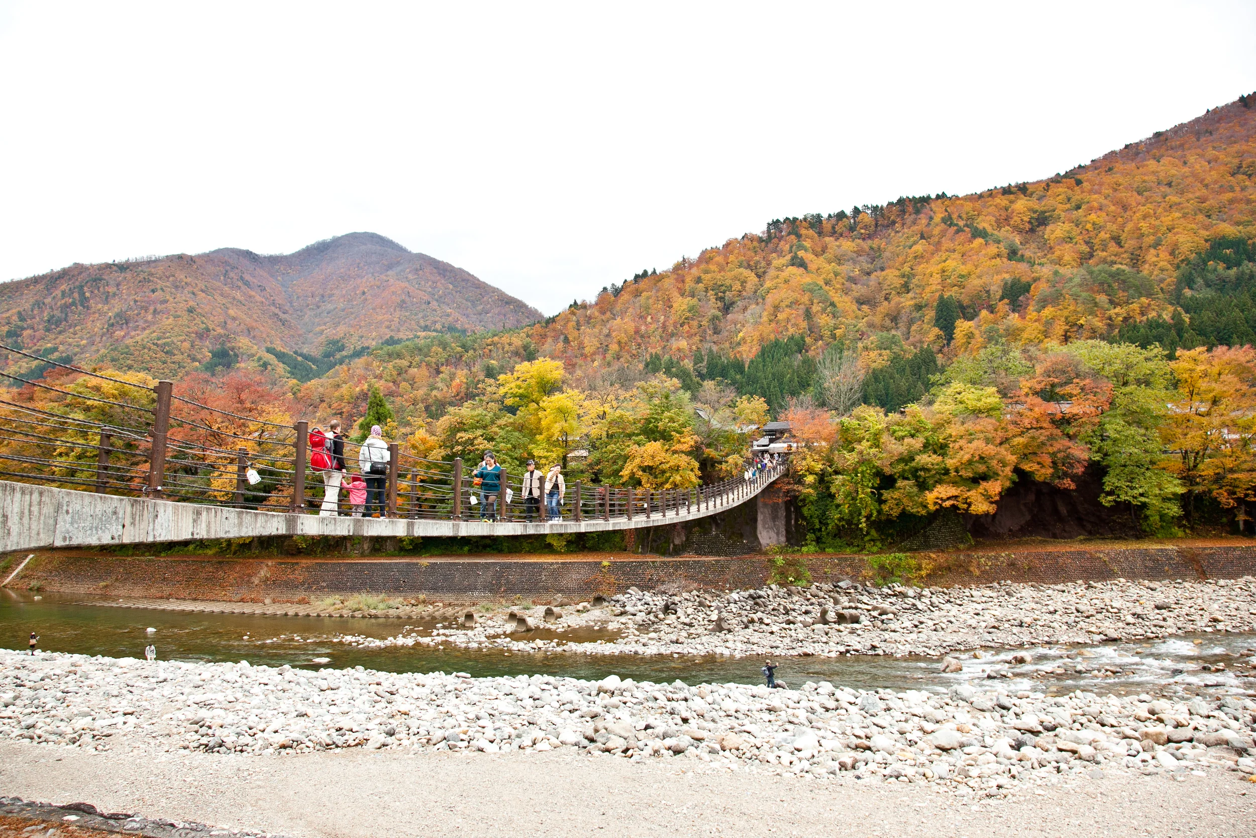 After arriving in Shirakawa-go by car, a suspension walking bridge brings you across the river into the village