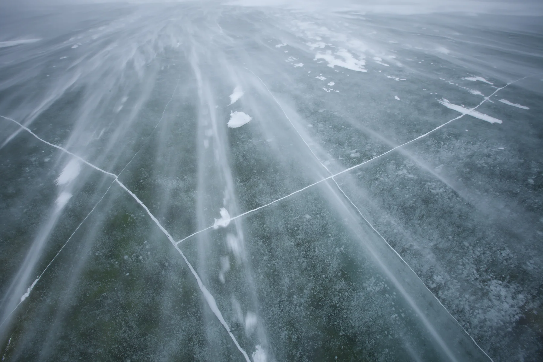 Heavy winds blow snow over a frozen pond in Jasper National Park, Canada. Image ©Connor Stefanison