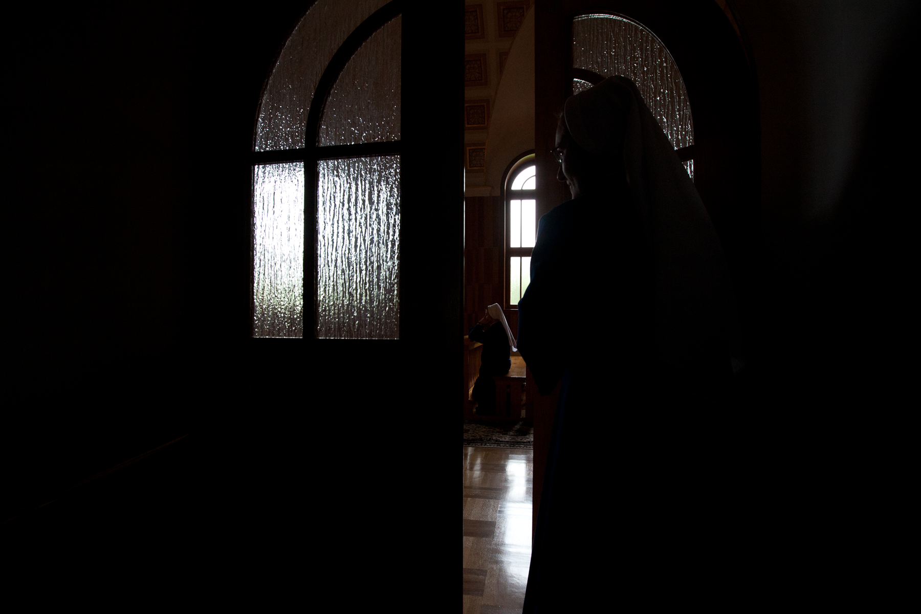 A catholic nun enters a convent chapel in southeast Poland. Image ©Connor Stefanison