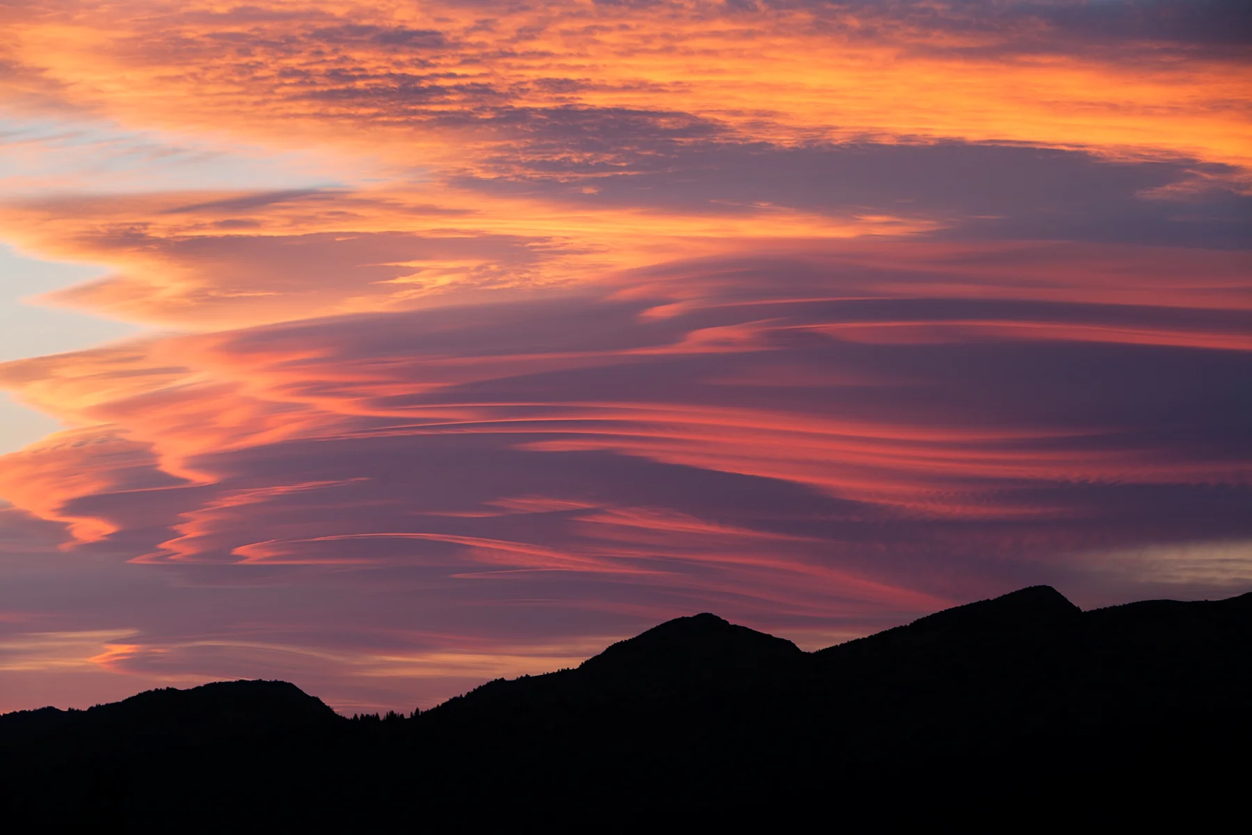 A vibrant sunset lights up lenticular clouds in Manning Provincial Park, B.C, Canada. Image ©Connor Stefanison