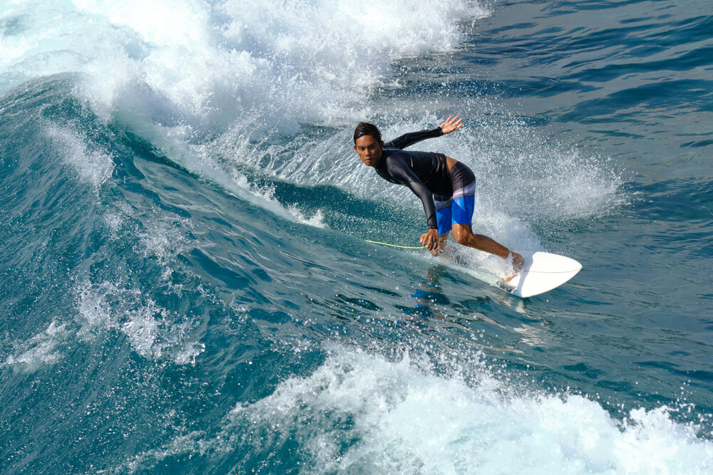 Surfer narazil do vĺn v Mahana Surf Point na ostrove Lembongan neďaleko Bali v Indonézii.  Ukážkový obrázok z Fujifilm XF 90mm f/2 R LM WR