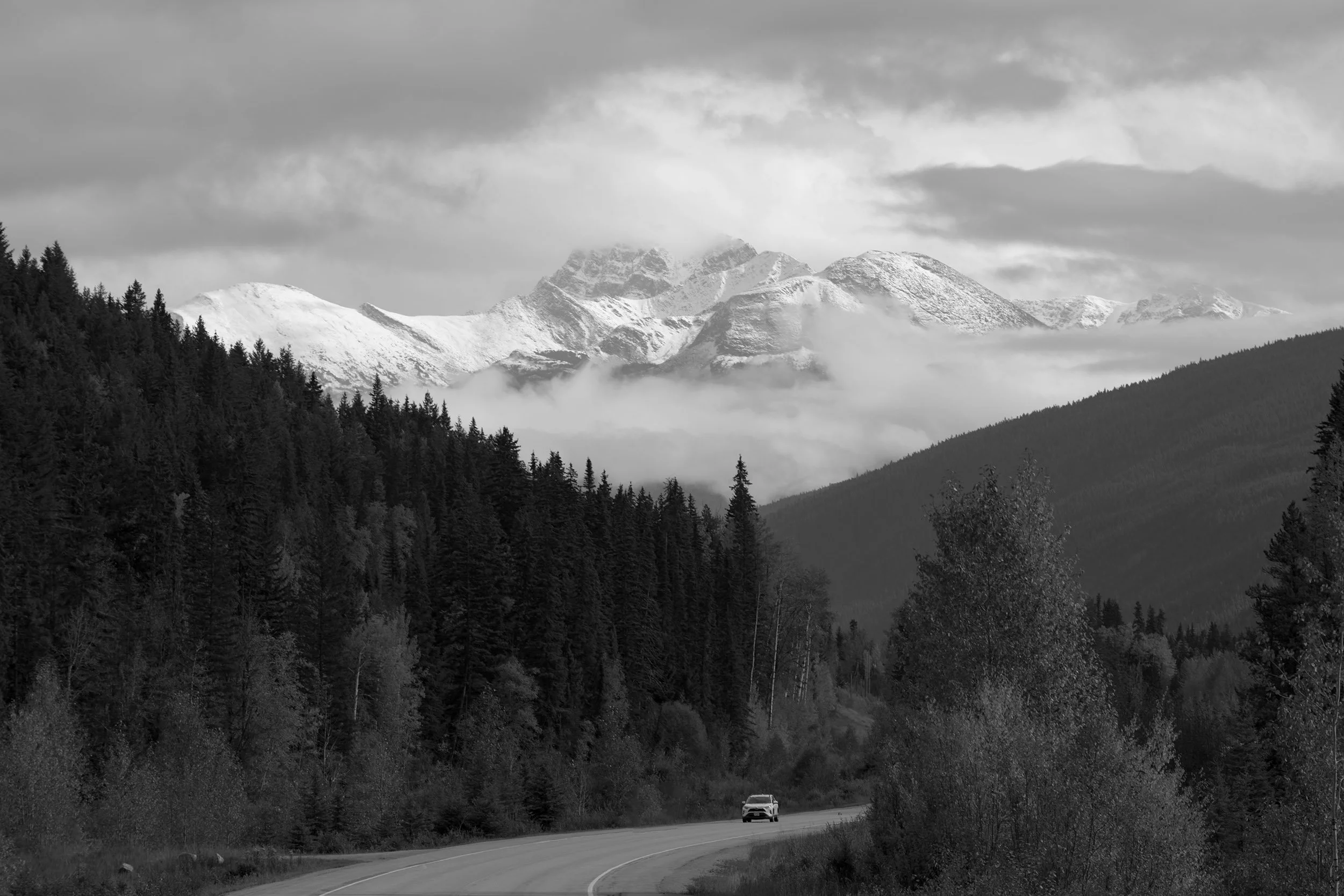 A lone car drives along the Yellowhead Highway between Mt. Robson and Jasper.