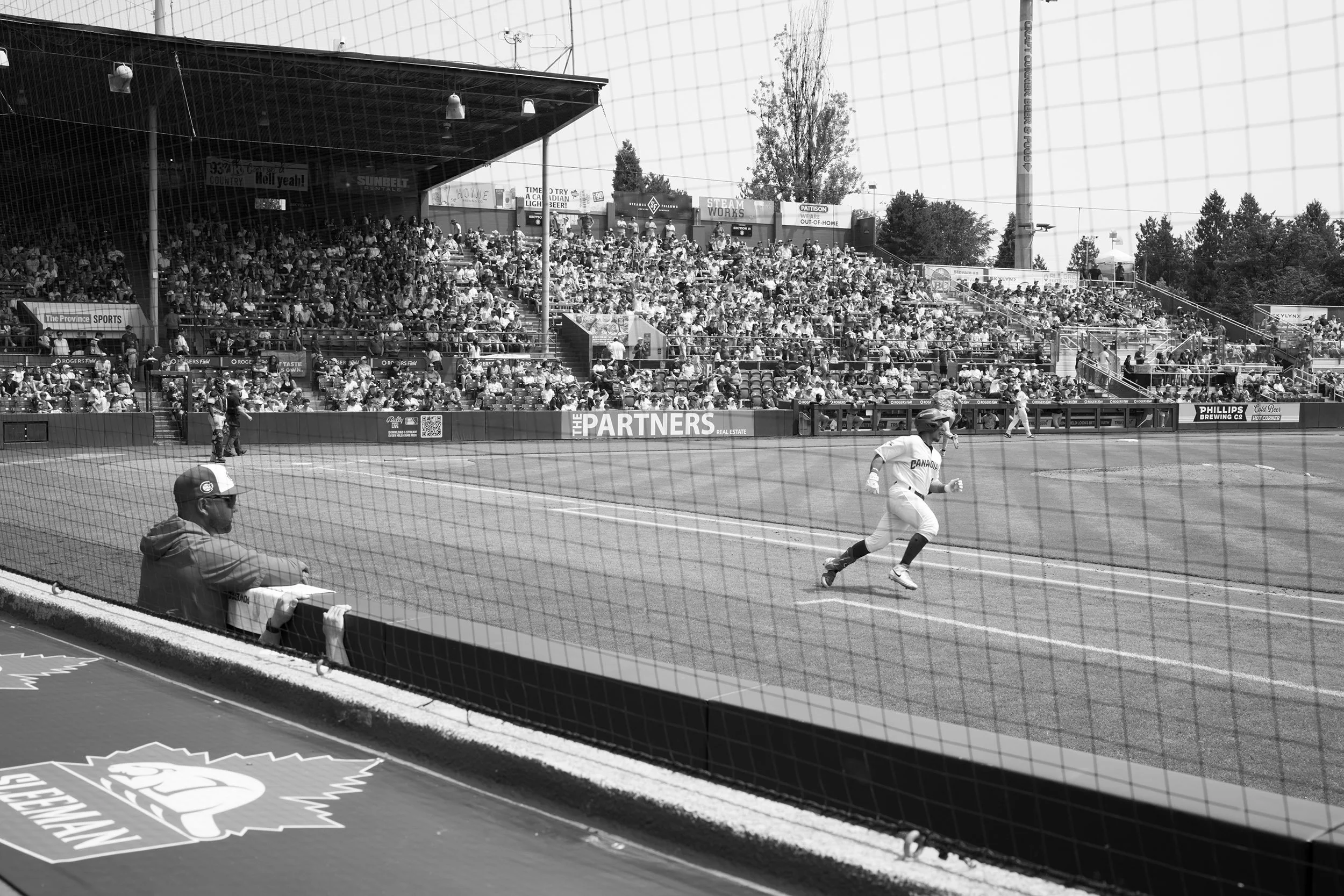 A black-and-white photo from the Vancouver Canadians playing baseball at Nat Bailey Stadium. Sample image from a Sigma 35mm f/1.4 DG II Art and Sony A7V.