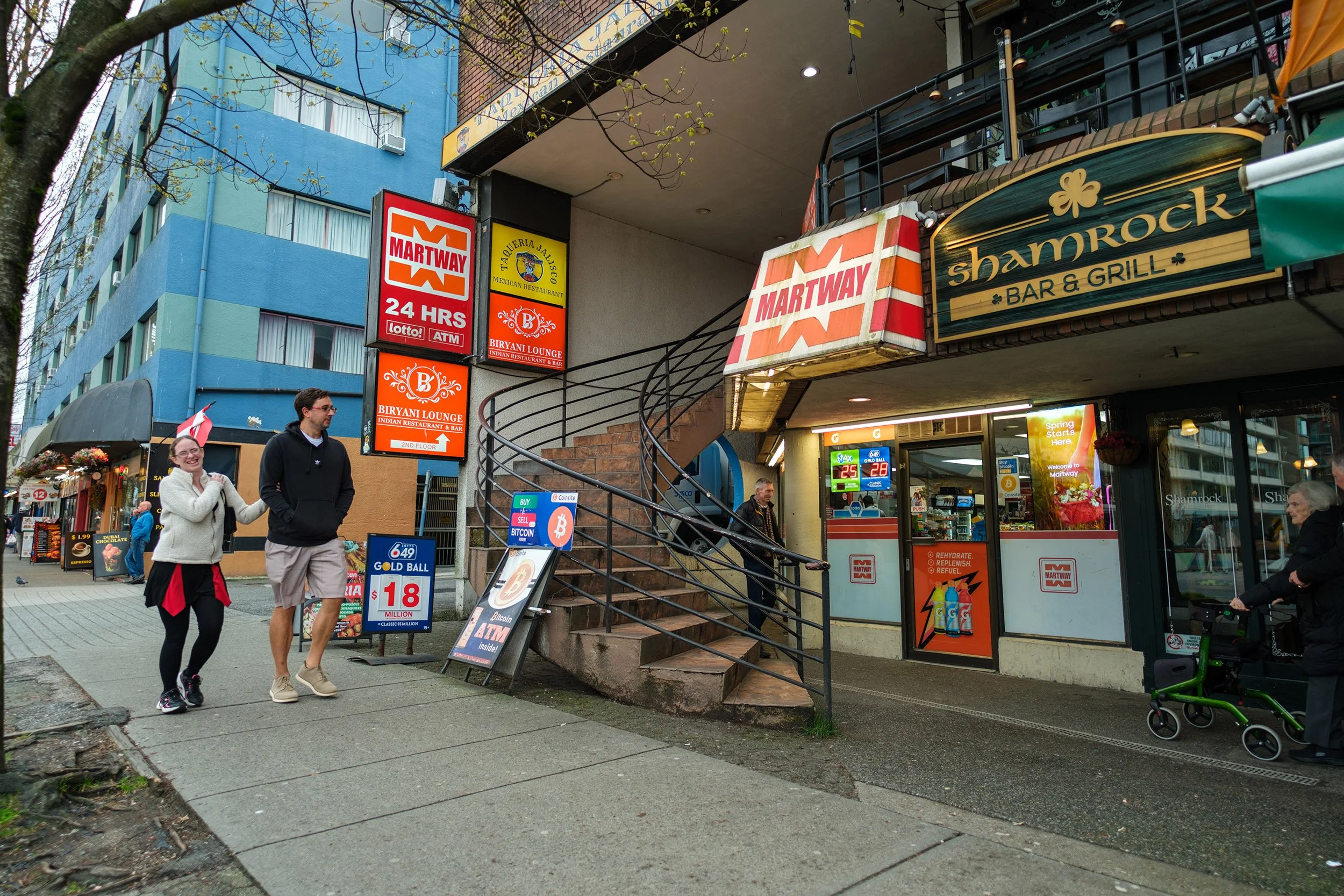 A couple walks down Denman Street in Vancouver. Sample image from a Sigma 15mm f/1.4 DC Contemporary and Fujifilm X-E5.