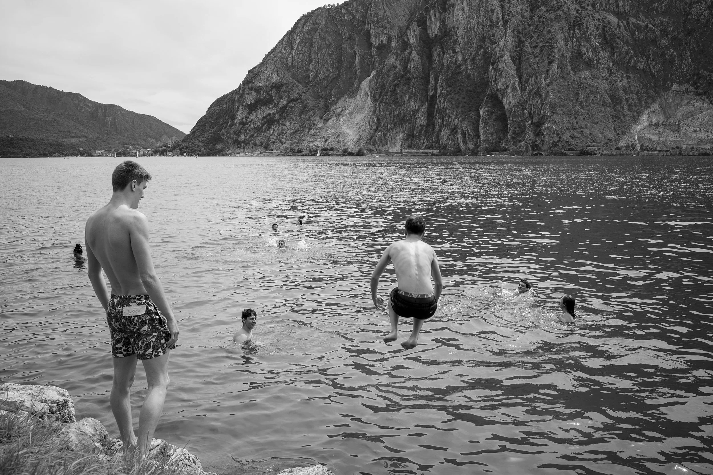 Young boys jumb in a lake near Lecco, Italy. Bergamo, Italy, Leica SL2-S, Voigtländer Nokton Vintage Line 28mm f/1.5 (M-Mount)