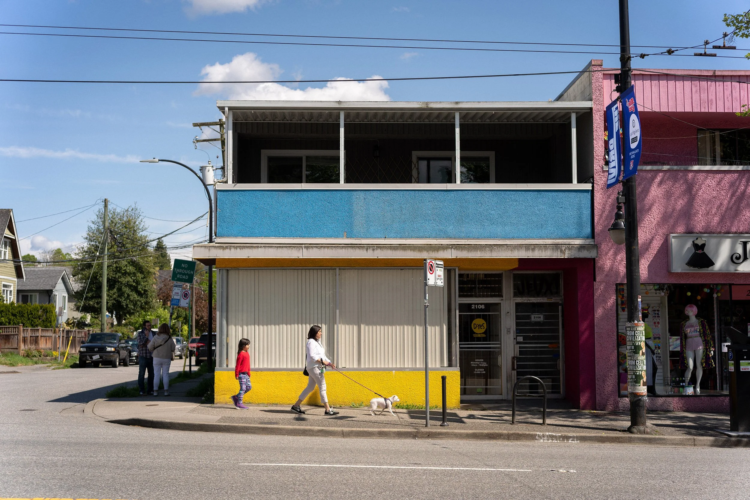 A woman walks her dog along Commercial Drive in Vancouver, Canada.