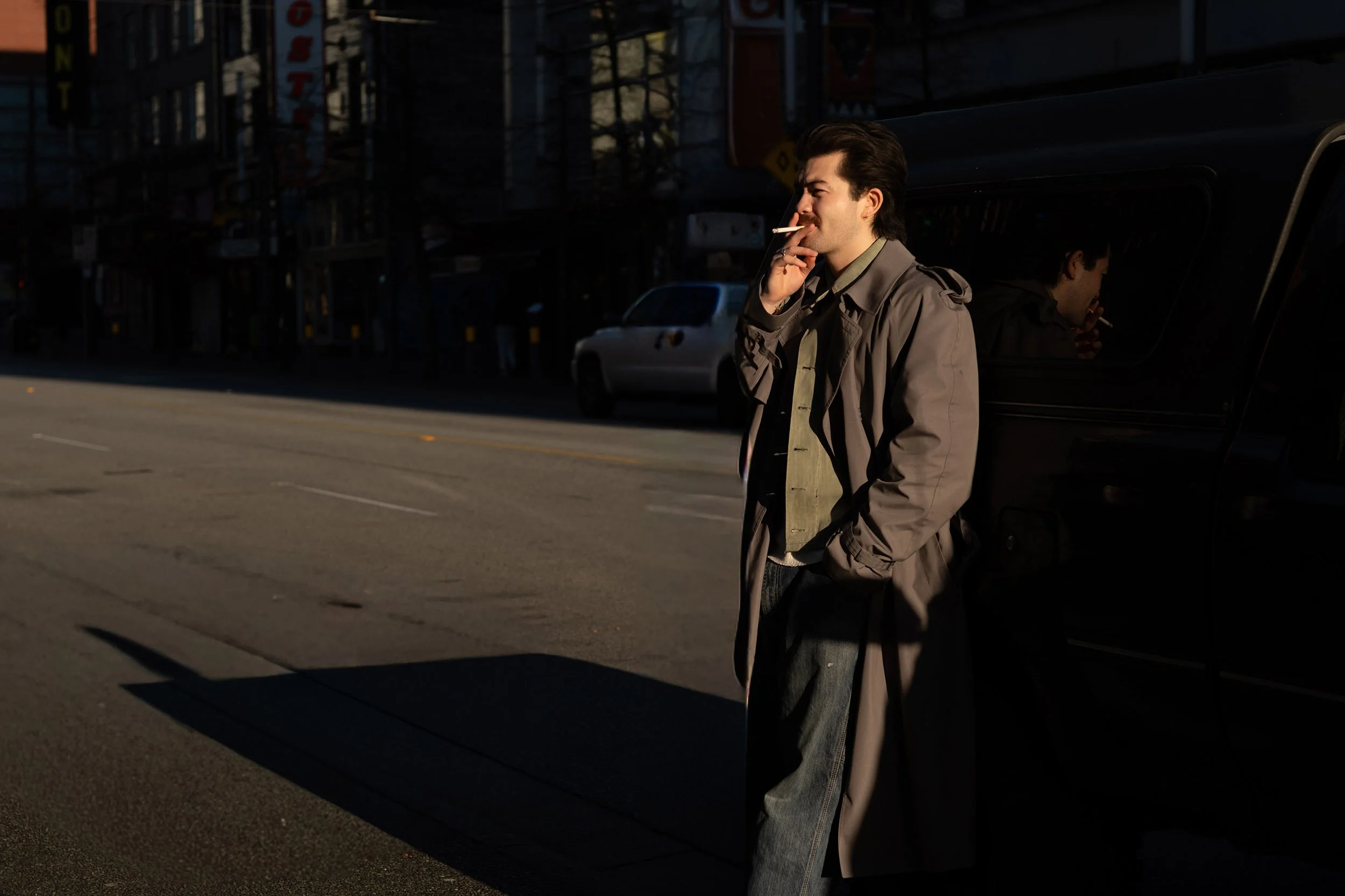A man is having a smoke on Granville Street in Vancouver. Street photography.