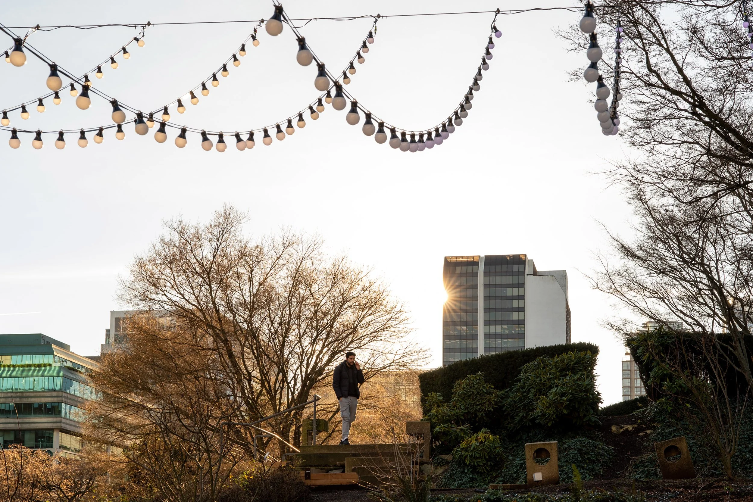A man is making a phone call from Robson Square in Vancouver. Sample image from a Sigma 17-40mm f/1.8 DC Art and Fujifilm X-E5.