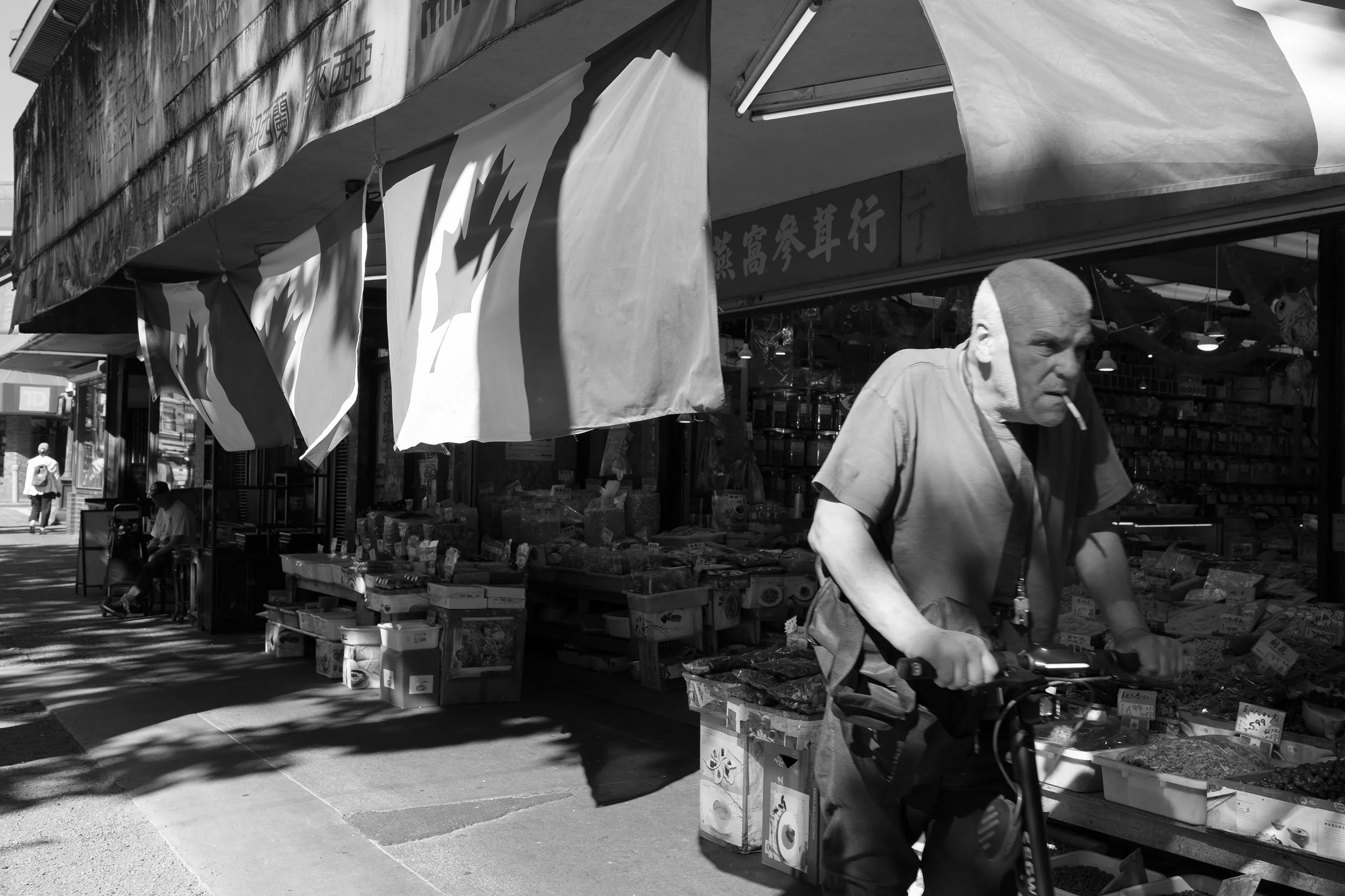 A man on an e-scooter in Chinatown, Vancouver. Sample image from a Fujifilm XF 23mm f/1.4 R LM WR and Fujifilm X-Pro2.