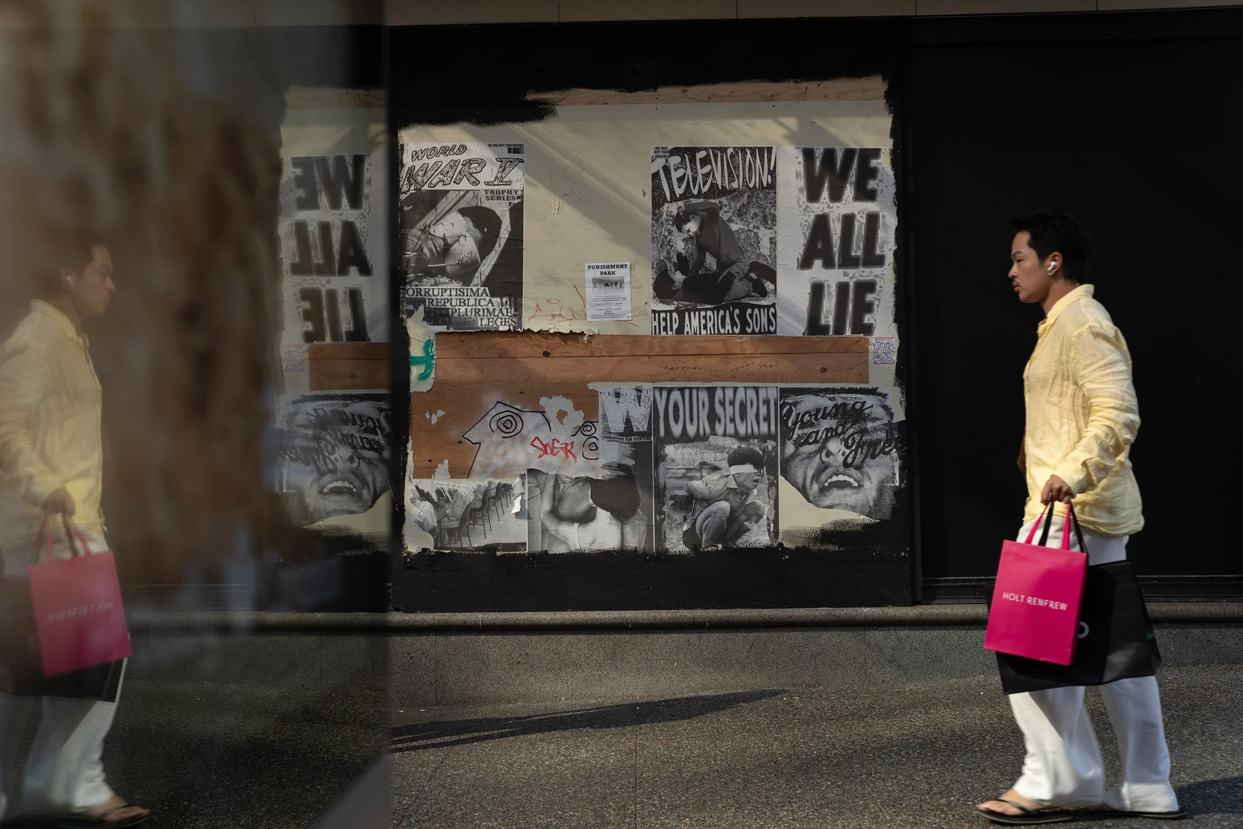 A man walks by posters on Granville Street in Vancouver