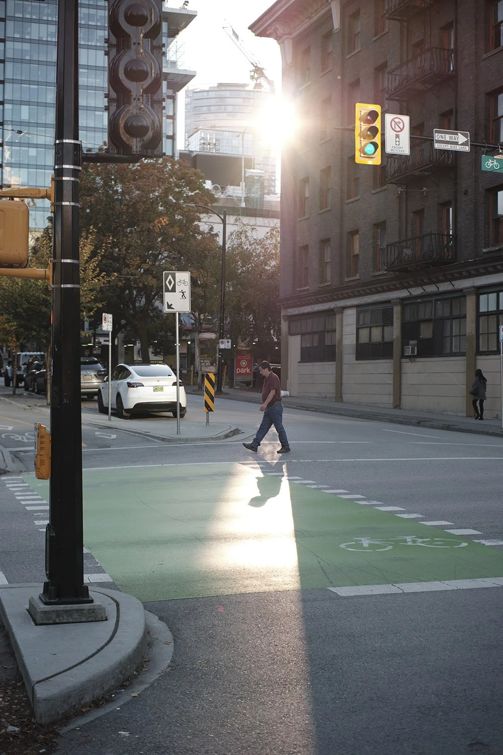 A man crosses the street in downtown Vancovuer. Sample image from a TTArtisan AF 35mm f/1.8.