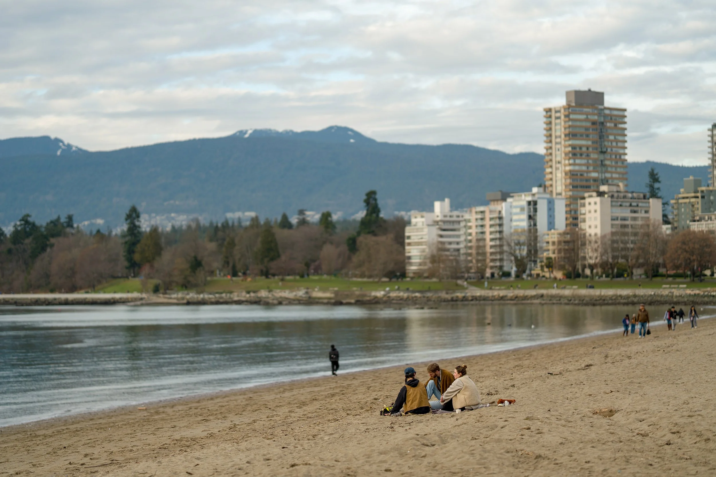 Friends gathered at English Bay Beach on a winter day in Vancouver.