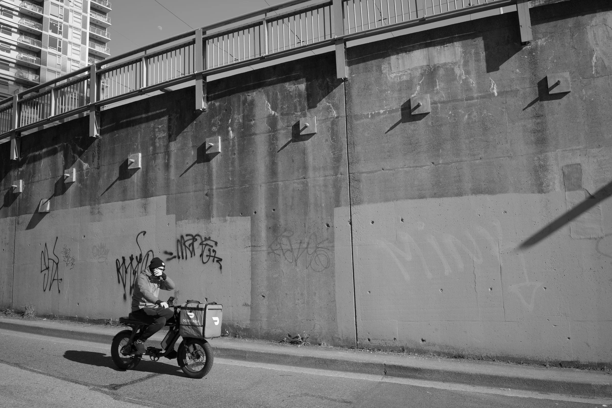 A door dash guy on his e-bike in Vancouver. Sample image from a Voigtländer Nokton Vintage Line 28mm f/1.5 (M-Mount) and Leica SL2-S.