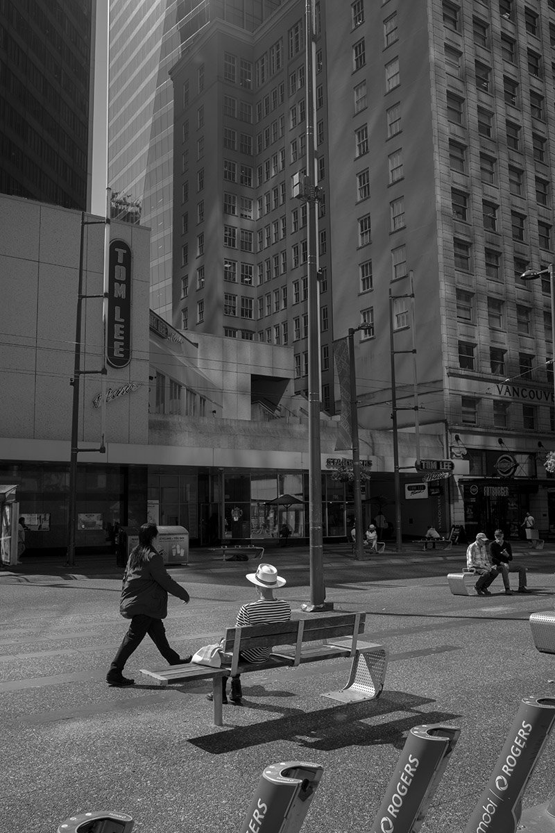 Man in a white sun hat, Granville Street, Vancouver. Sample image from a Voigtländer Nokton Vintage Line 28mm f/1.5 (M-Mount) and Leica SL2-S.