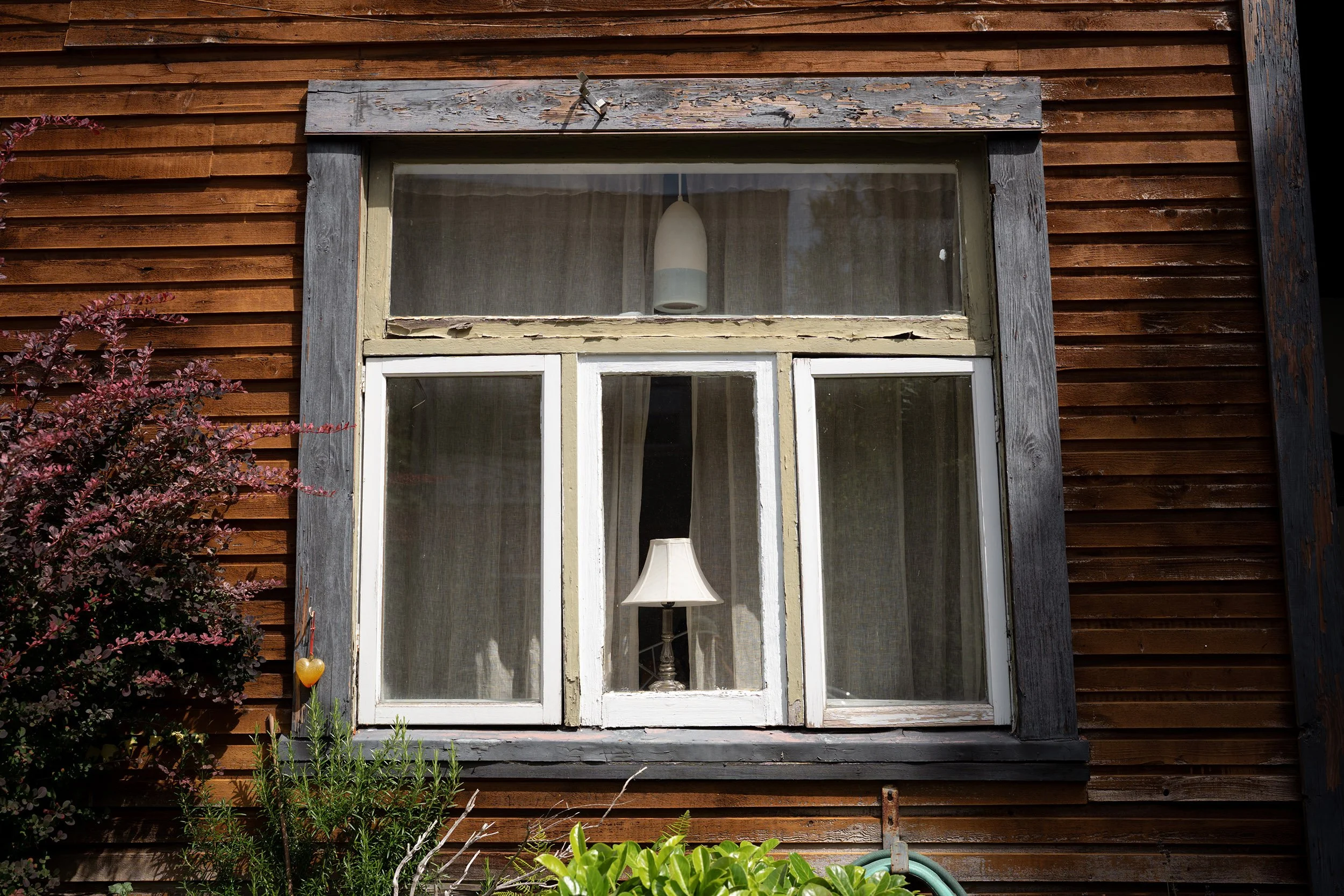 Lamps in a window of a Vancouver Heritage House, July 2026
