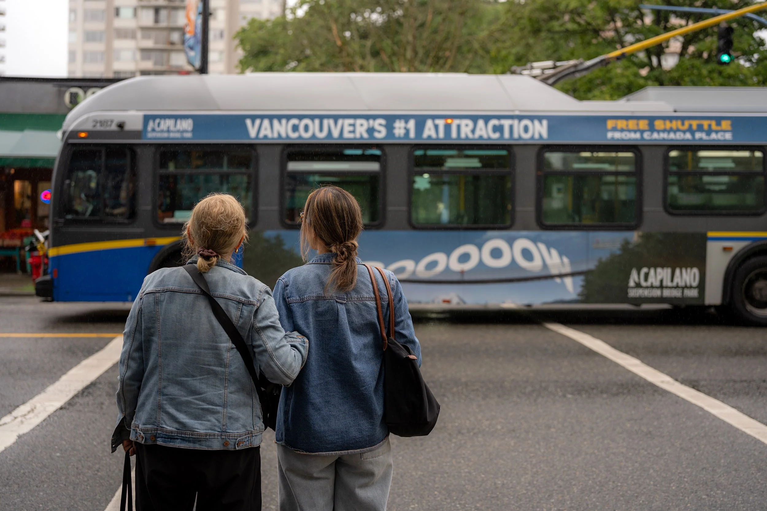 Mother and daughter waiting at Denman Street cross walk in Vancouver, July 2, 2026
