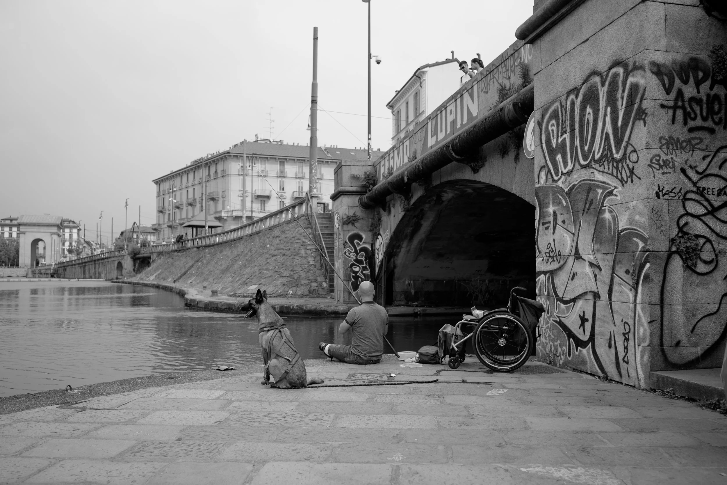 A man is fishing in the canals of Milan, Itatly. Sample image from a Voigtländer Nokton Vintage Line 28mm f/1.5 (M-Mount) and Leica SL2-S.