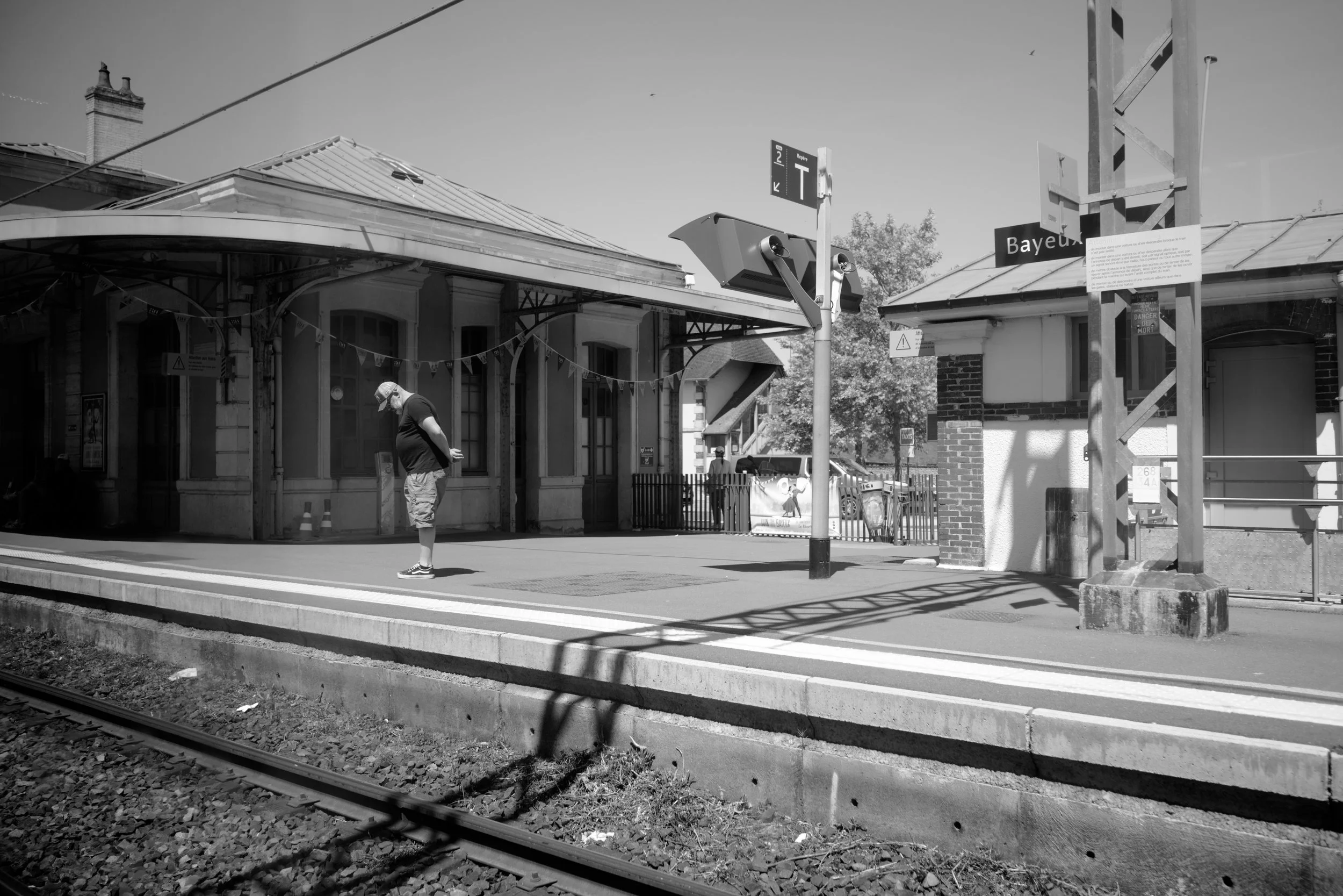 A man waits for a train in Normandy, France. Sample image from a Voigtländer Nokton Vintage Line 28mm f/1.5 (M-Mount) and Leica SL2-S..