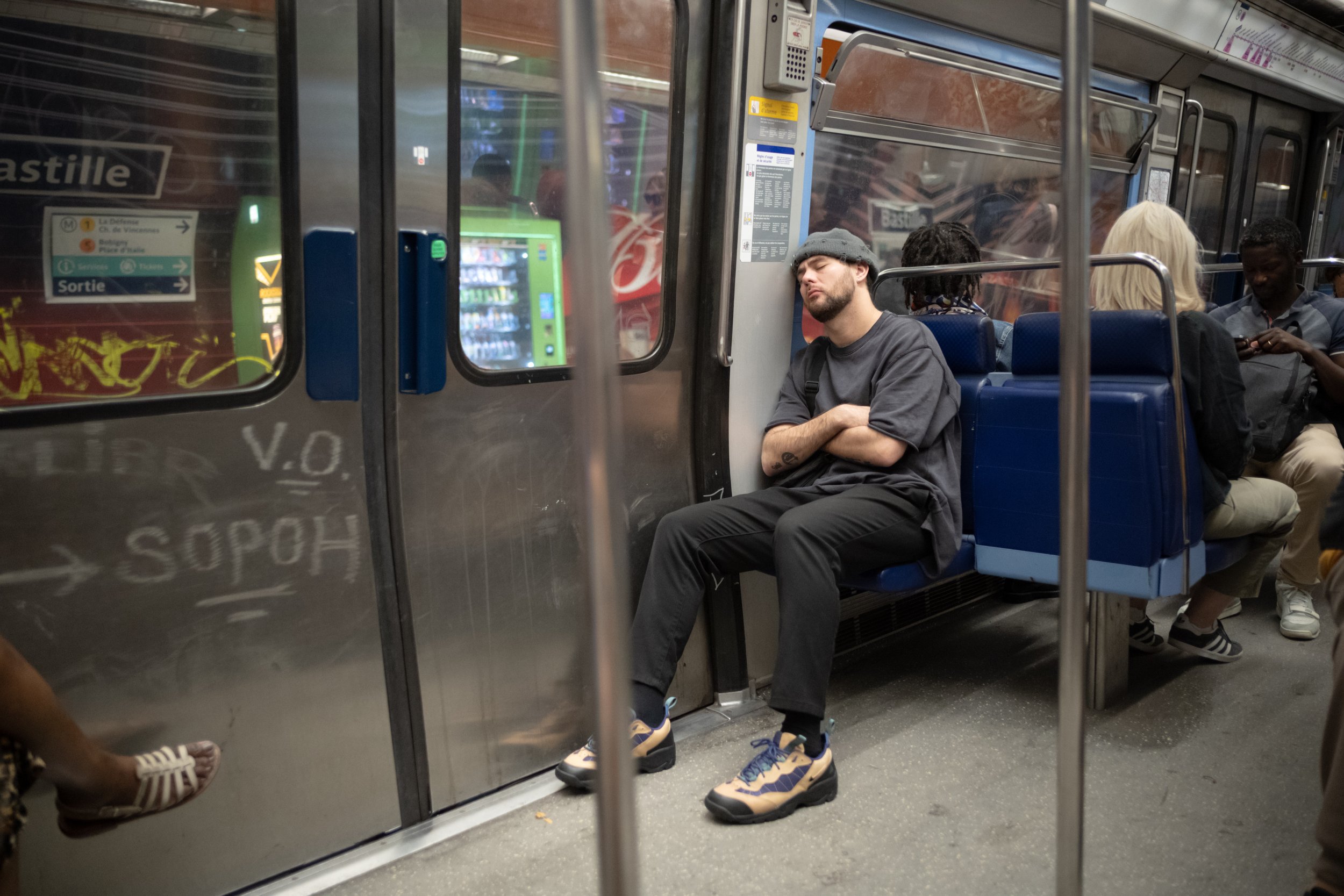 A man is sleeping on the Paris Metro. Sample image from a Voigtländer Nokton Vintage Line 28mm f/1.5 (M-Mount) and Leica SL2-S.
