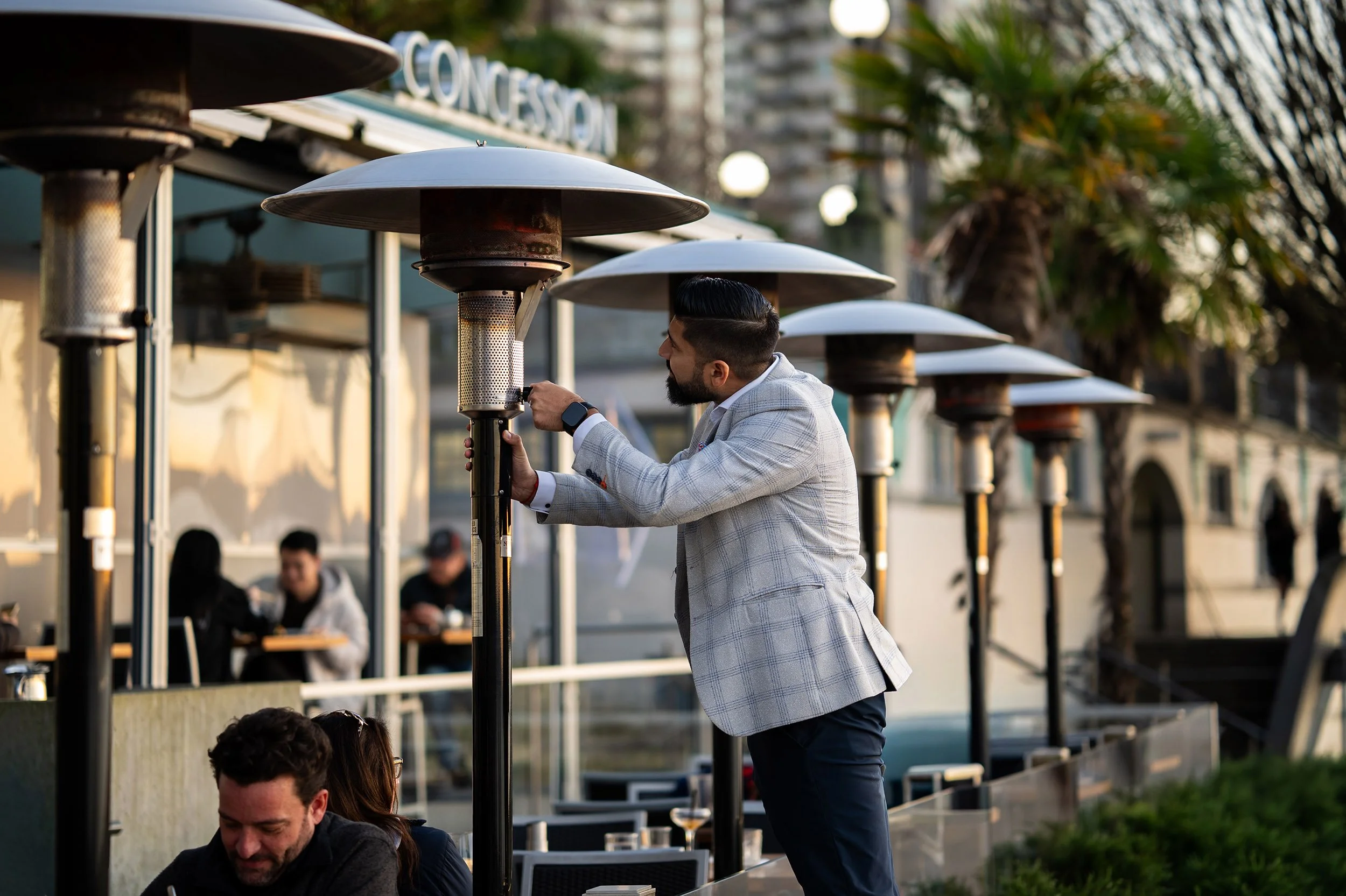 Man turns on an outside heater at Cactus Club. Tree and reflection, Coquitlam River. Sample image from a Viltrox 56mm f/1.2 Z (Nikon Z-Mount) and Nikon Z8.