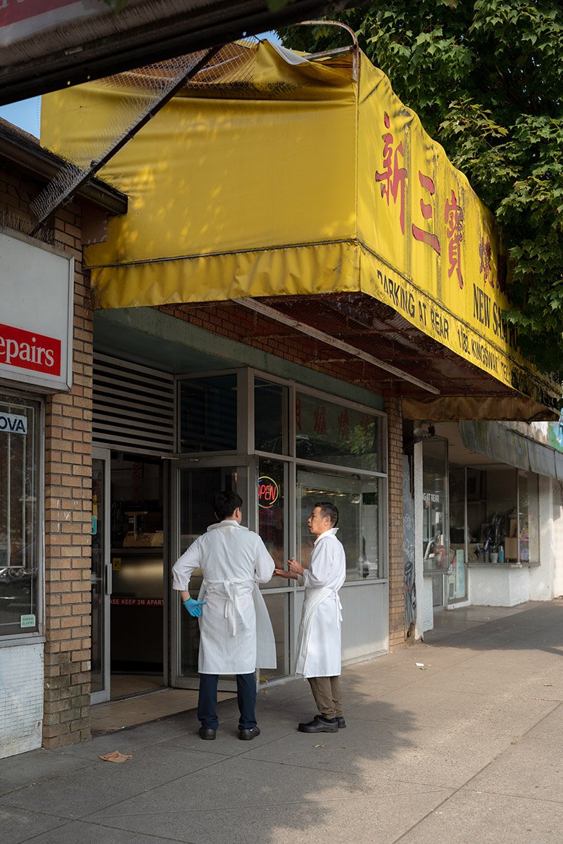 Two men outside a meat shop on Kingsway in Vancouver. Sigma 35mm f/1.4 DG II Art (Sony E-Mount) on a Sony A7V.