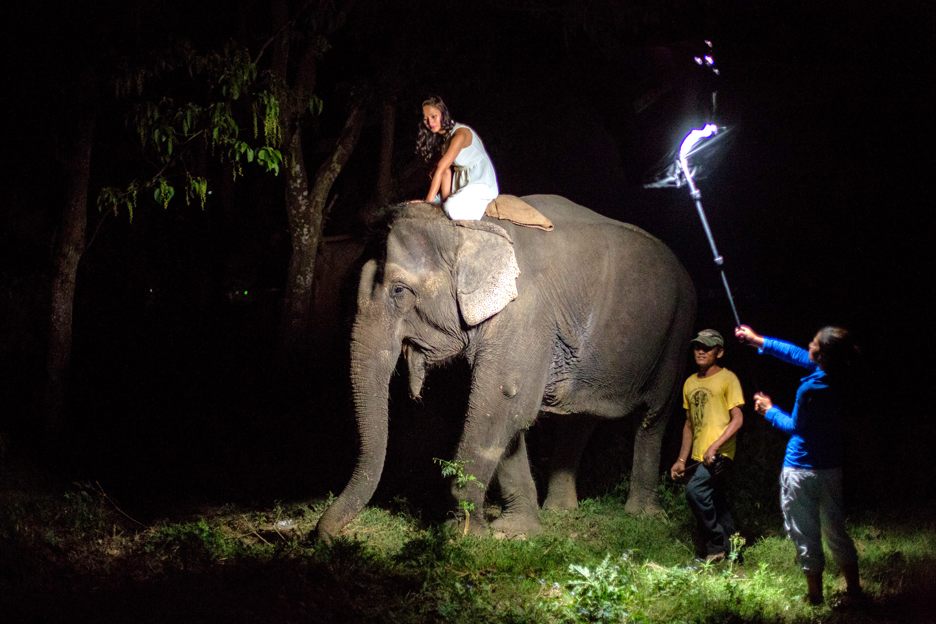 Behind the scenes of the shoot. Samjhana lighting the scene and our friend taking care of the Elephant. 