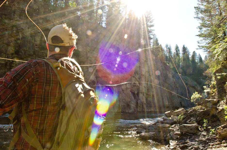  The morning sun streams down as it rises above a canyon while Kurt Ross casts for bull trout. South Fork of the Flathead River, 2013 