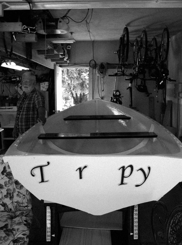 Caretaker Greg Schaffner stands next to the 12-foot dinghy he and my dad worked on for nearly two years. August 2010.