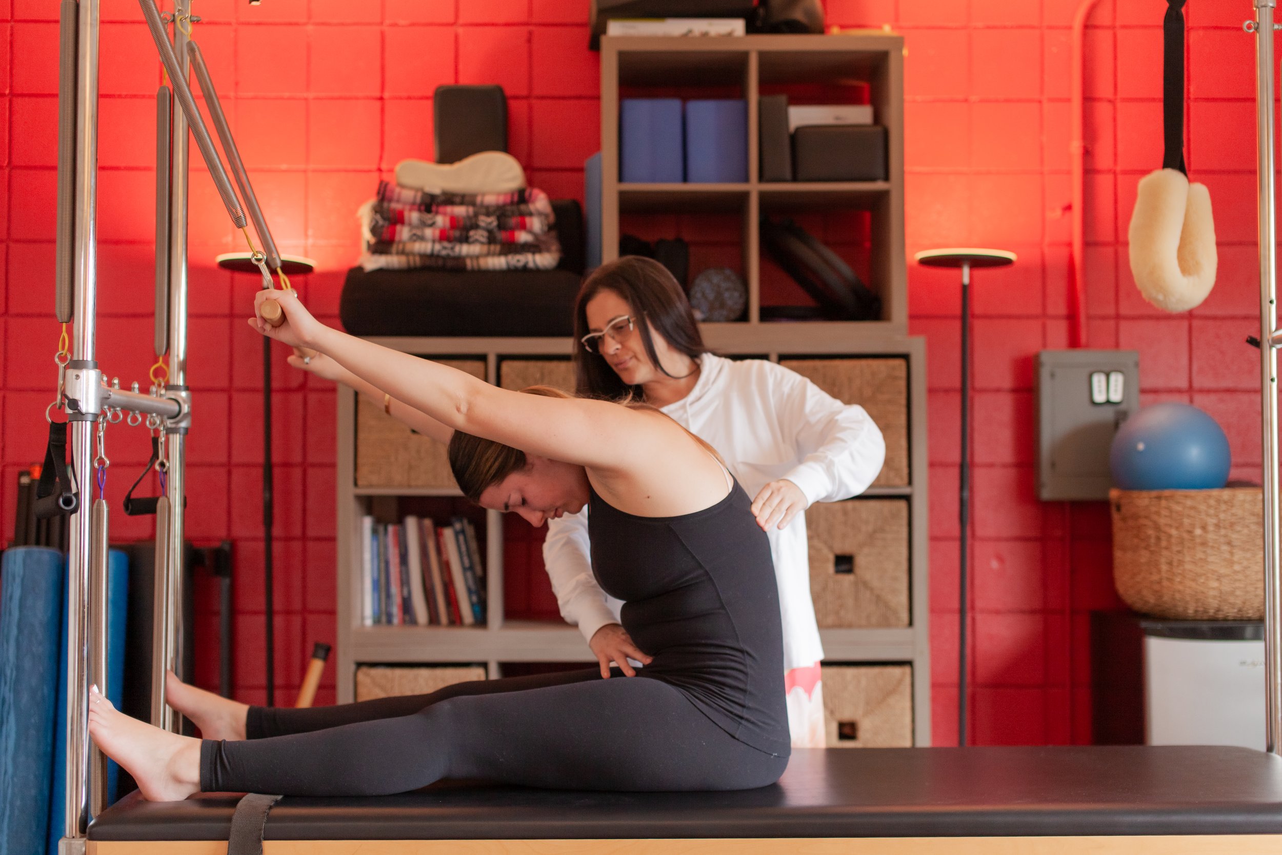 Shabnam guiding client on pilates Cadillac machine
