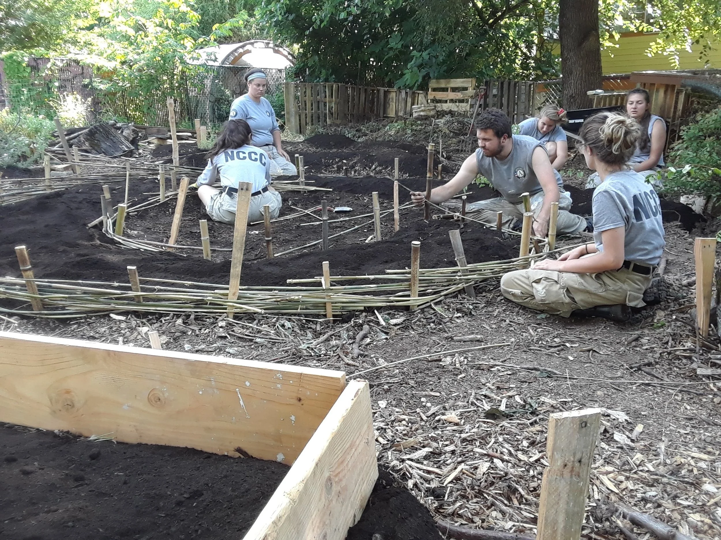 An AmeriCorps crew helps build an herb labyrinth.