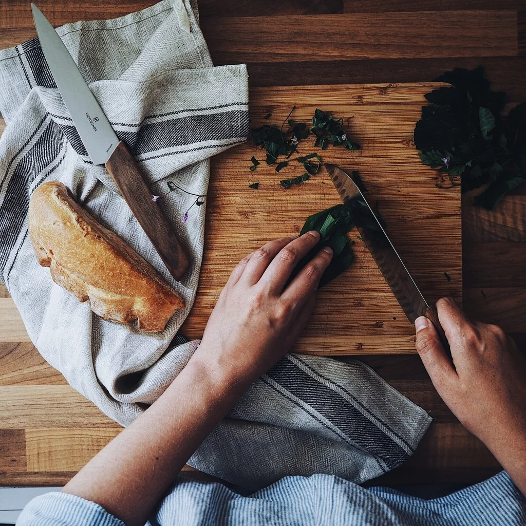 Girl chopping wild garlic on a wooden surface.jpg