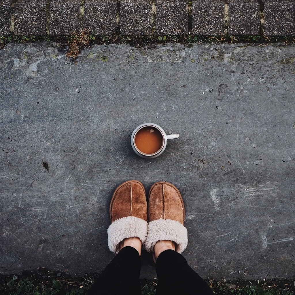 Brown slippers and cup of tea on a grey step.jpg