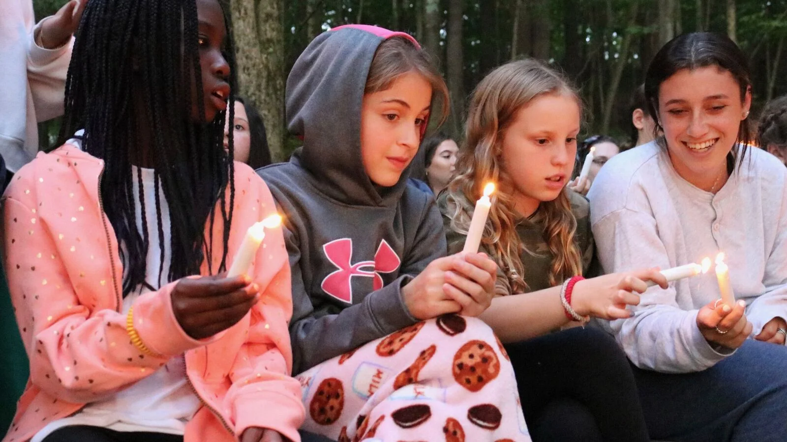 An Iconic Scatico Moment: Sienna, Olivia, Kate, and Rachel light their candles at the Opening Campfire.