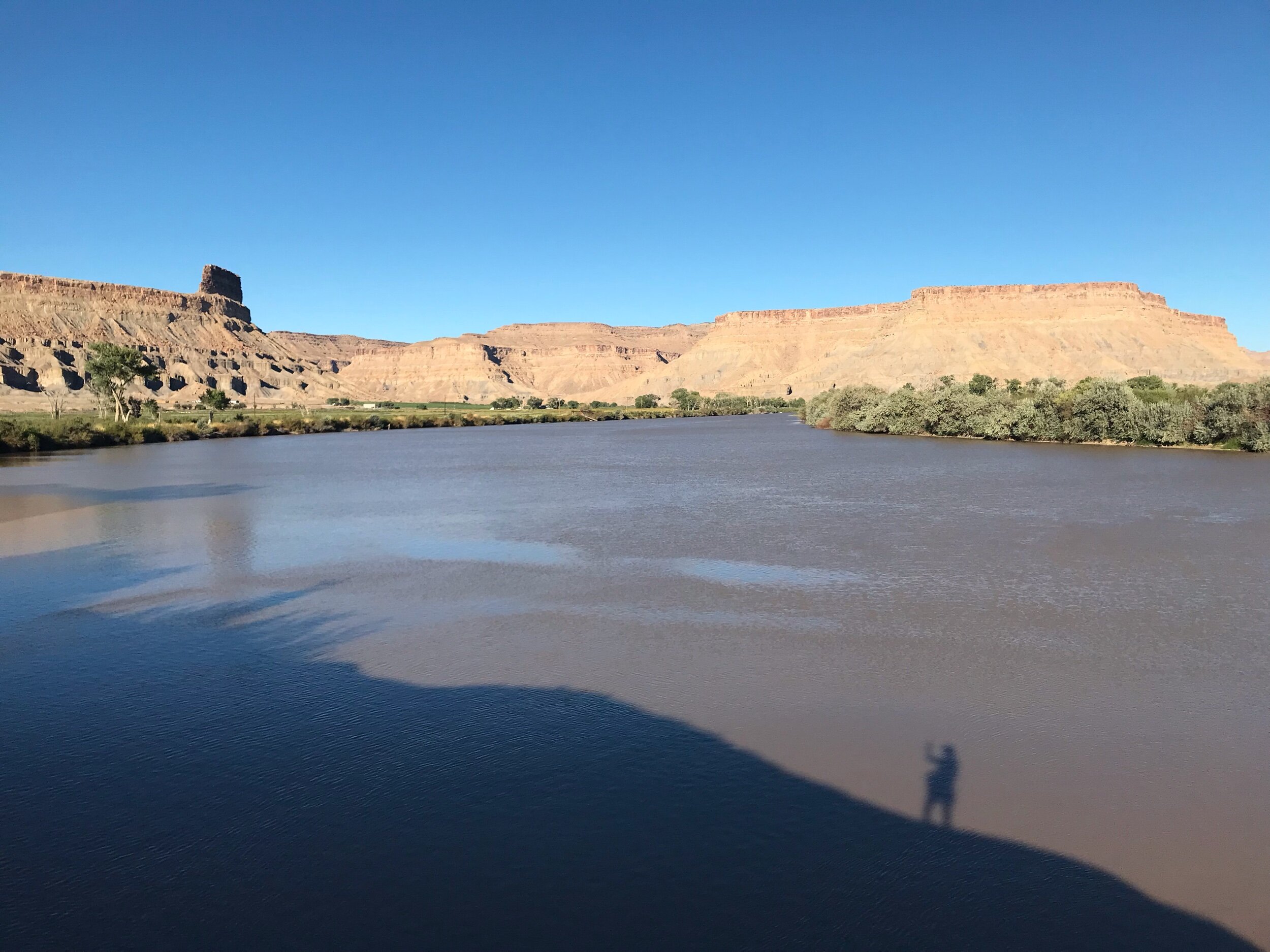 Green River with Book Cliffs in the background and Blanca’s shadow