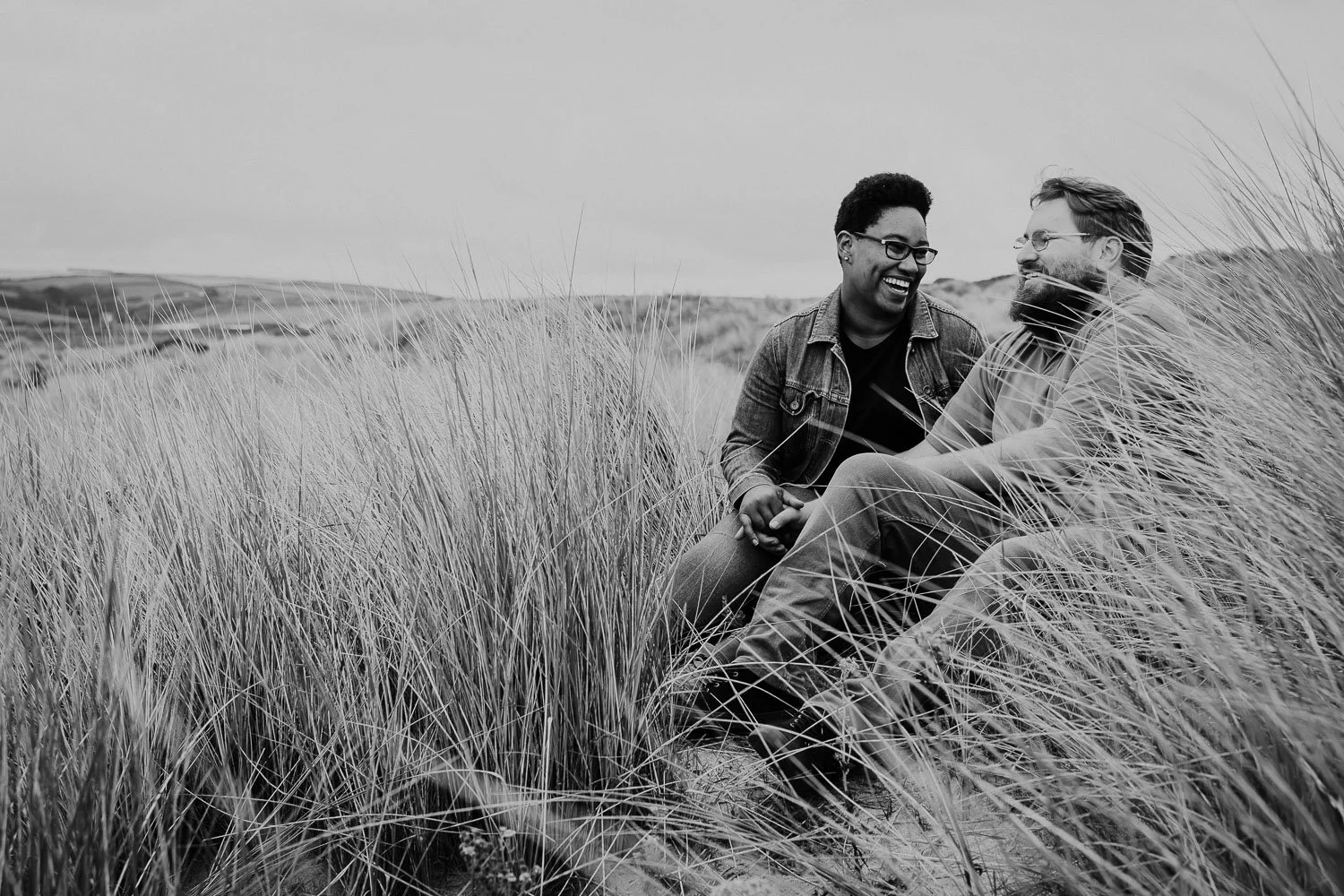 Sitting Couple Portrait in Sand dunes. Black and White Photo