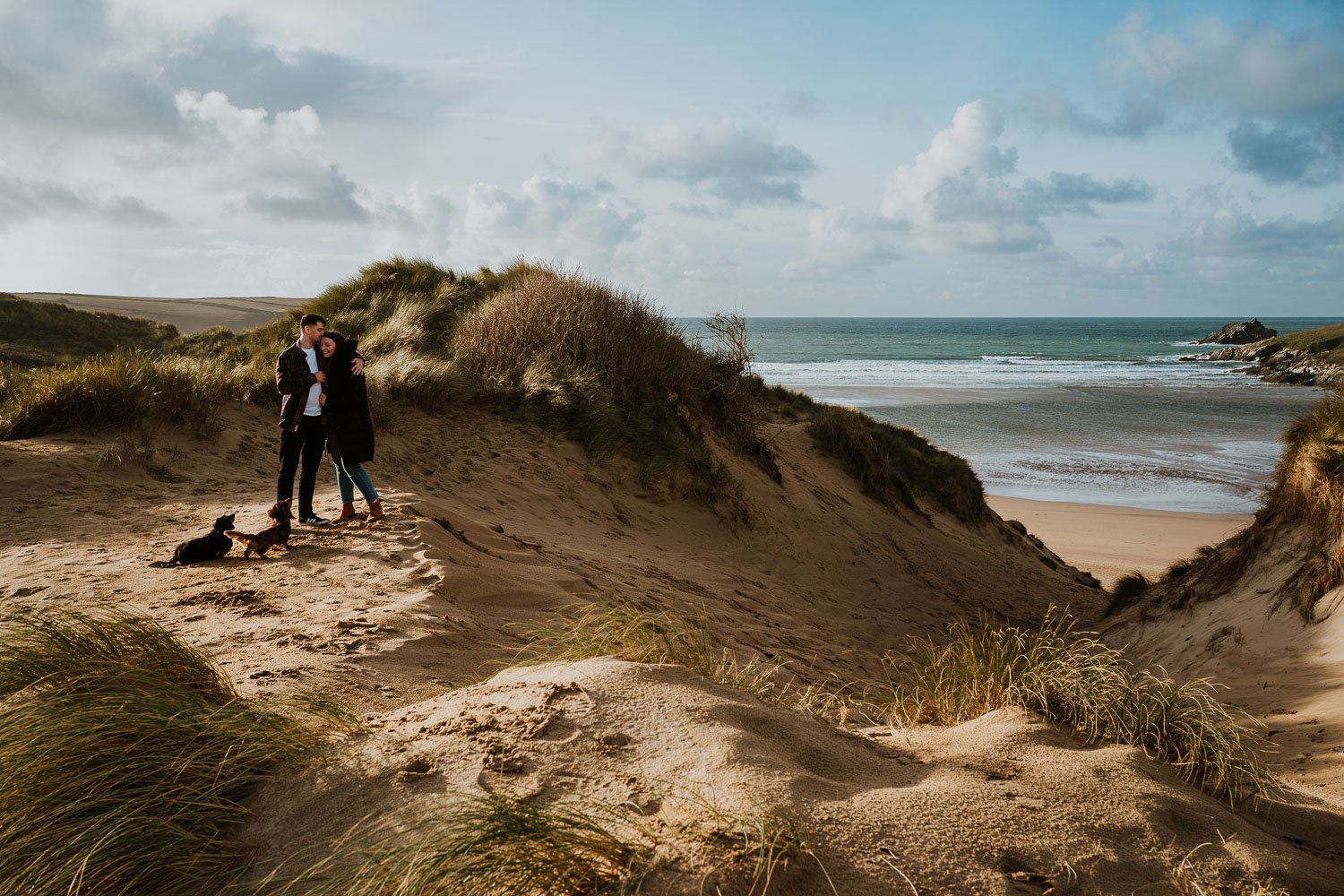 Engagement Photo of couple and their dog on the beach in Cornwall