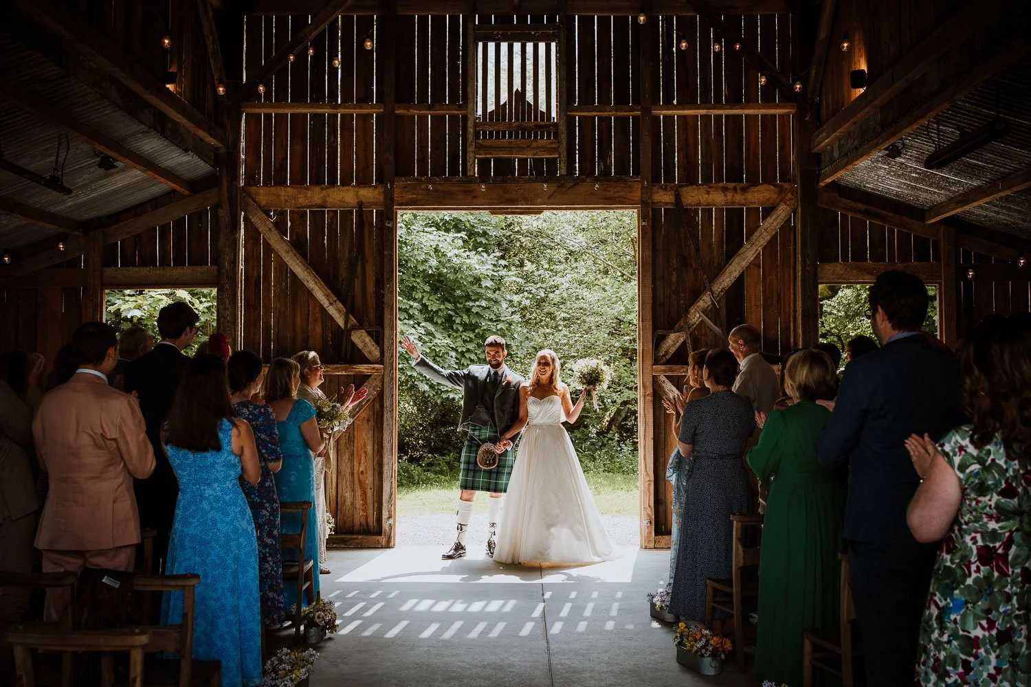 Bride and groom holding hands and cheering just before walking down the aisle. Guests cheering. Wedding Ceremony exit