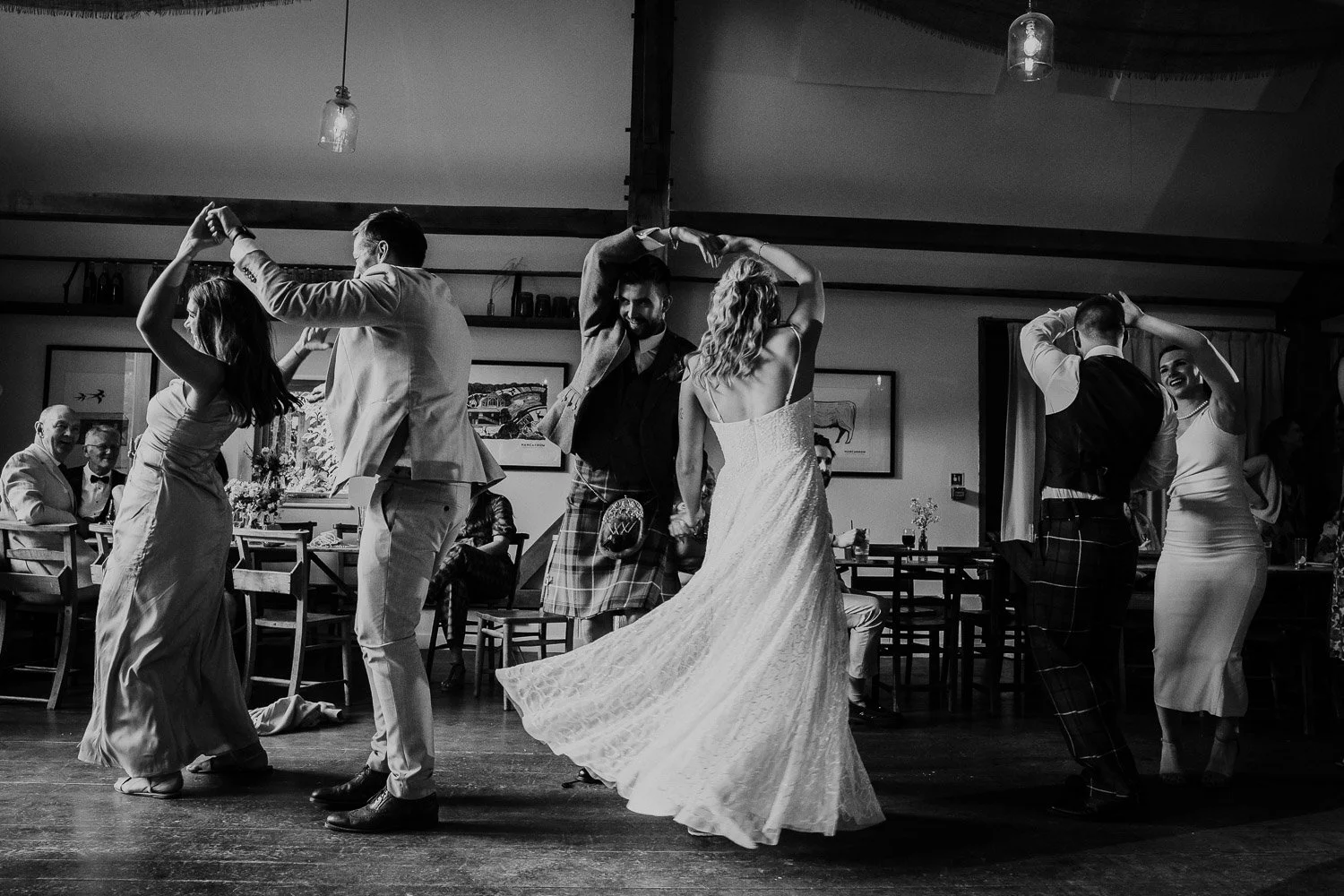 People dancing at a wedding reception, with the bride and groom in the center. Wedding reception party photo. Black and White Photo