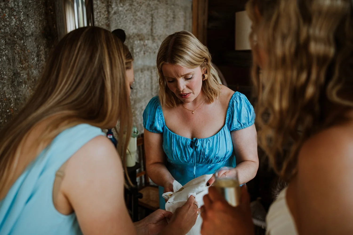 Bridesmaids helping bride clean her wedding dress soiled during a couple portrait session