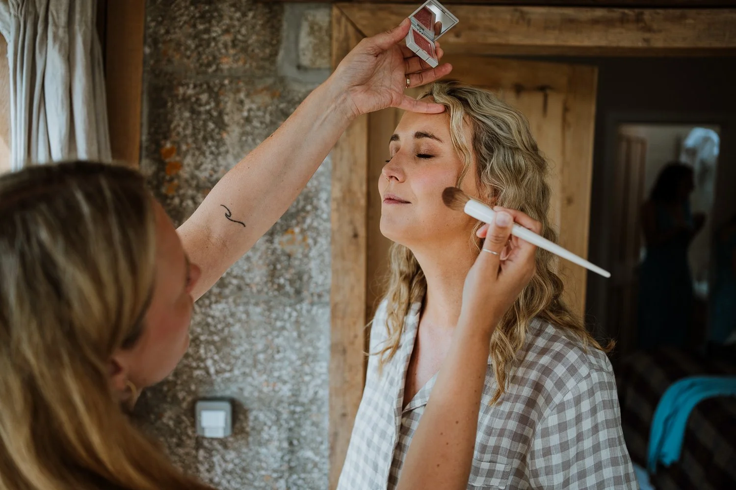 A bride having her face makeup applied by the makeup artist. Bridal Preparation Photo