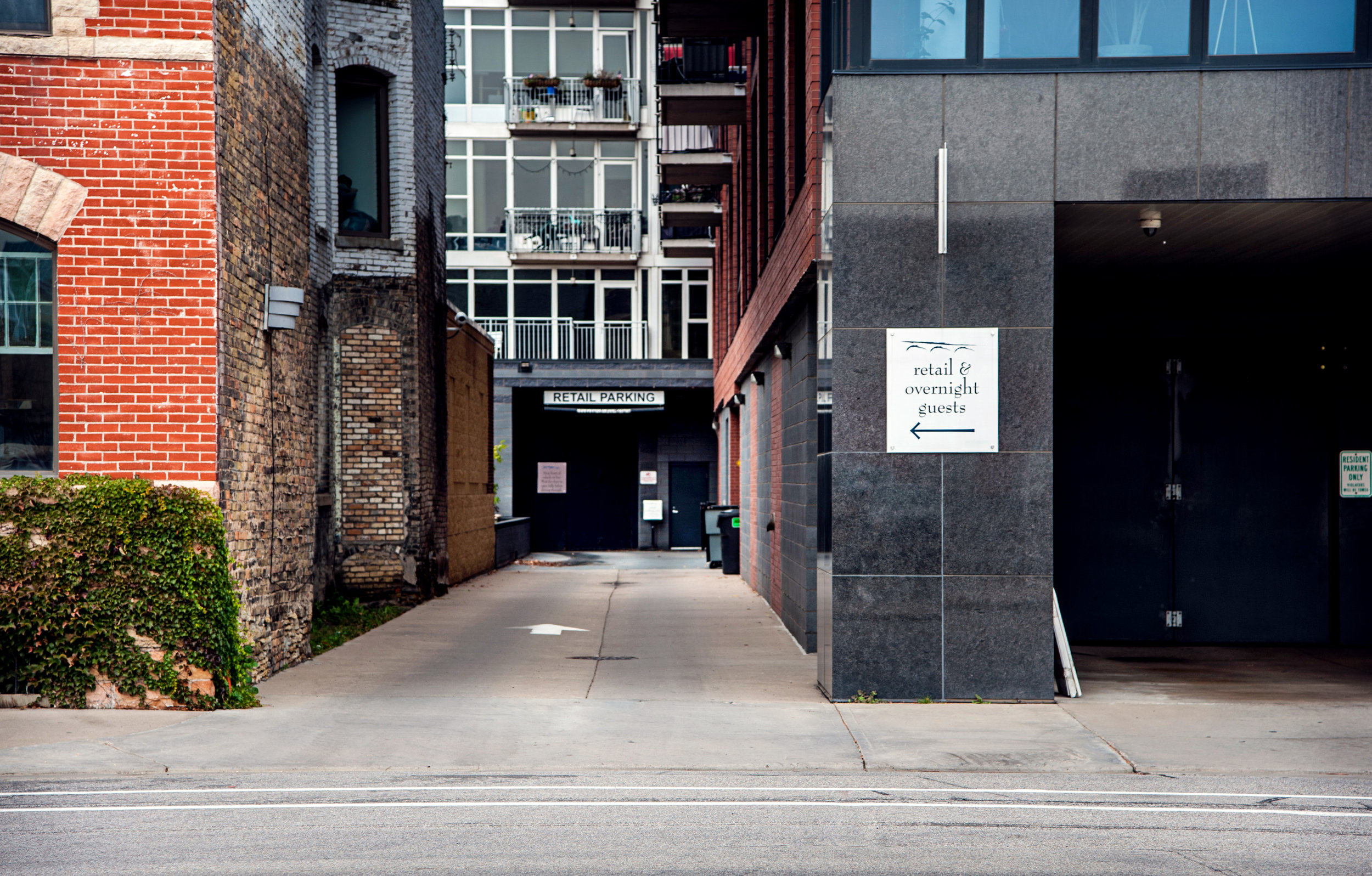 Proceed to the end of the alley, pause, and the doors will magically open. Free parking inside. Look for our big green banner .