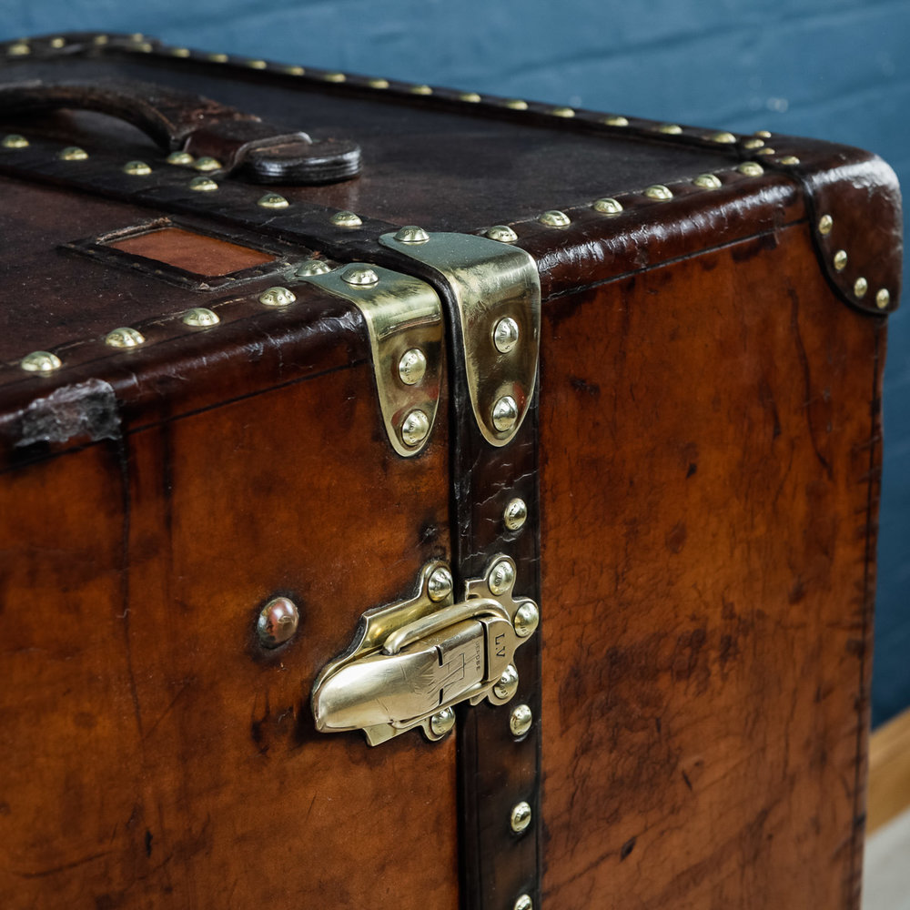 Roseberys London  A Louis Vuitton wardrobe trunk, 20th century, with brass  and leather edges, with hanging space and four stamped hangers with a  ratchetted rail
