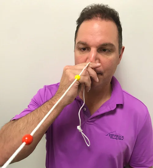 Mike is seen here completing a visual exercise to strengthen how his eyes work together in order to fix his blurred and double vision.