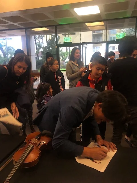 Students surround one of the Villalobos Brothers in the Downey Theatre lobby, seeking autographs. Photo courtesy Downey Theatre