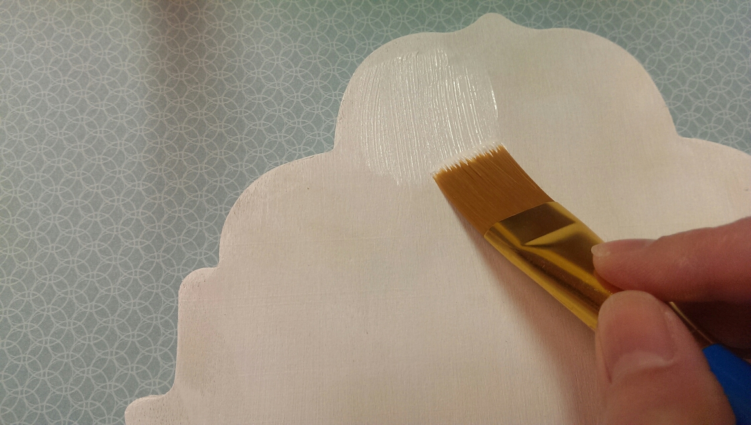 Applying the second coat of white acrylic paint to the wooden plaque.