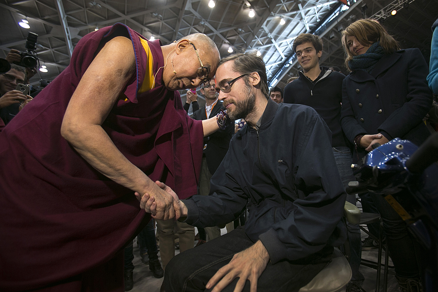 The 14th Dalai Lama greets a person in a wheelchair after an appearance at Princeton University's Jadwin Gym.