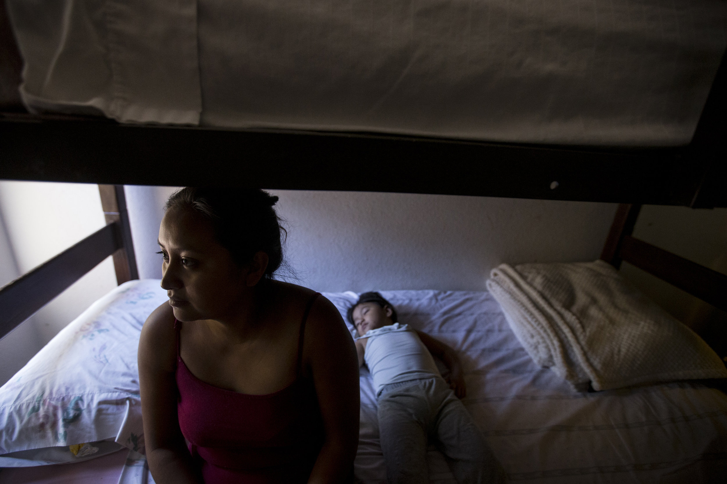 Erica Gomez Claudia, 21, of Guatemala, sits for a portrait while her daughter, Briani Fuentes Gomez, 2, sleeps at Casa Alitas migrant shelter in Tucson, Ariz. Gomez Claudia left Guatemala after she was estranged from her family and men threatened to rape her.