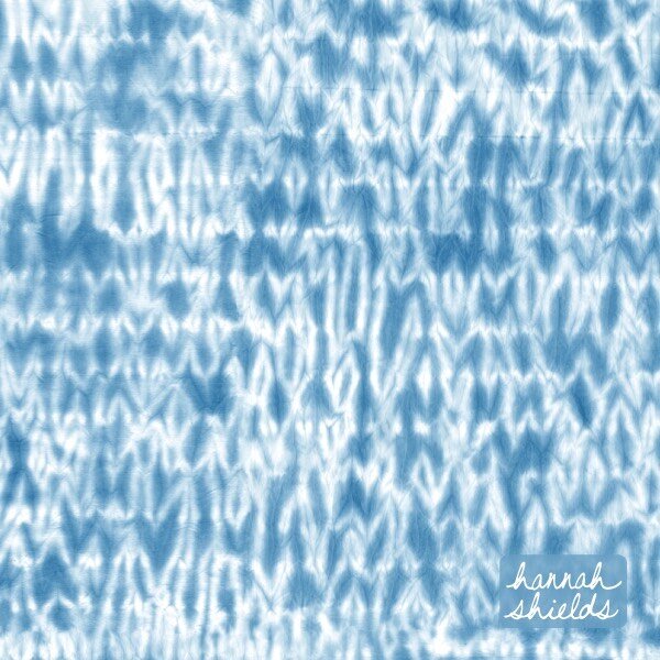 I created this design using traditional shibori dyeing techniques on fabric, then scanned the pieces to make a repeat pattern. This rippled technique is created by stitching the fabric in parallel lines before dyeing. You can see the stitch marks as 